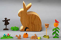 wooden animals, flowers and vegetables in a rabbit box